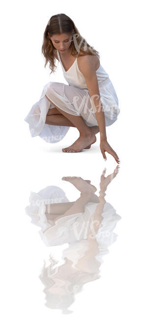 woman in a white dress squatting by the pool