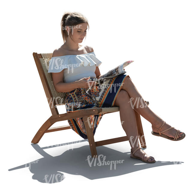 woman sitting in an armchair outside and reading a magazine