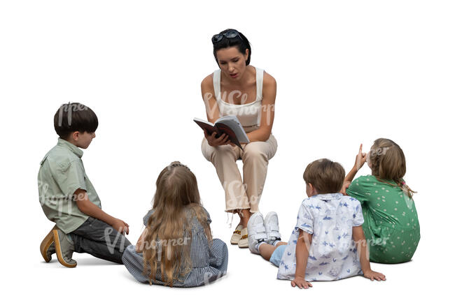 woman sitting and reading a book to a group of children