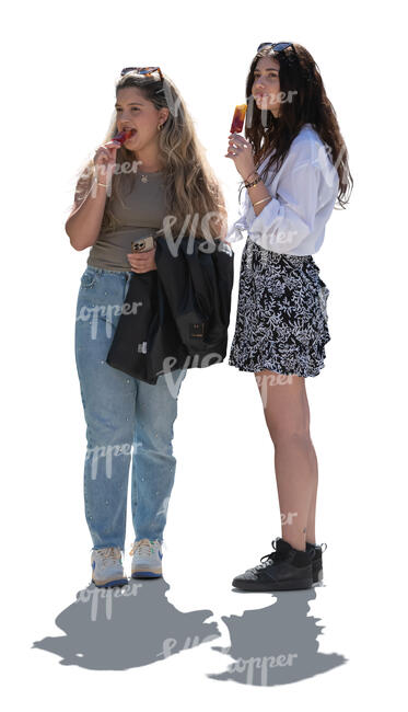 two backlit young women standing and eating ice cream