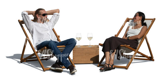 two people sitting in sling chairs and drinking wine