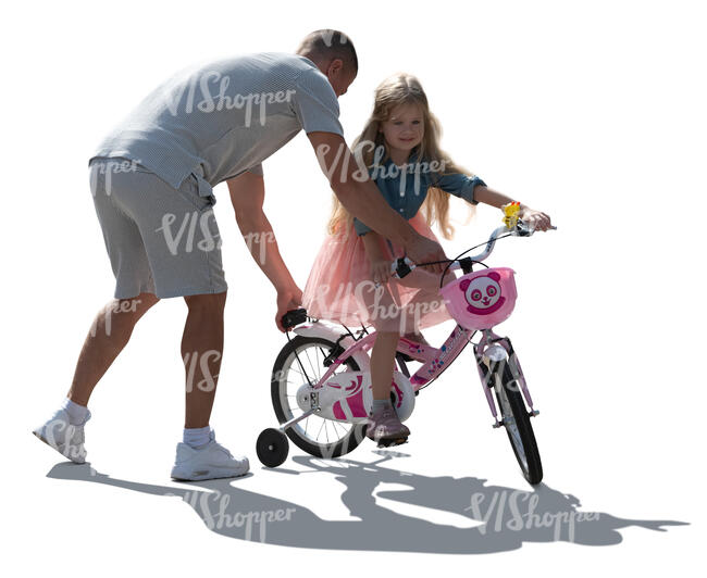 backlit man helping her daughter to ride a bike