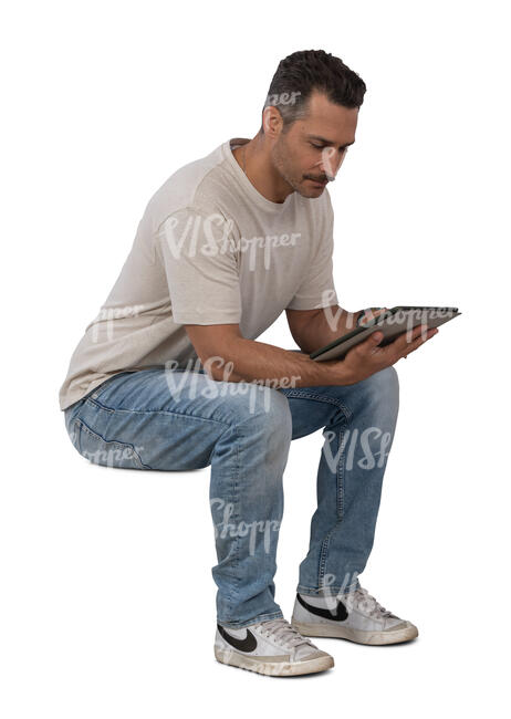 man sitting and looking at tablet