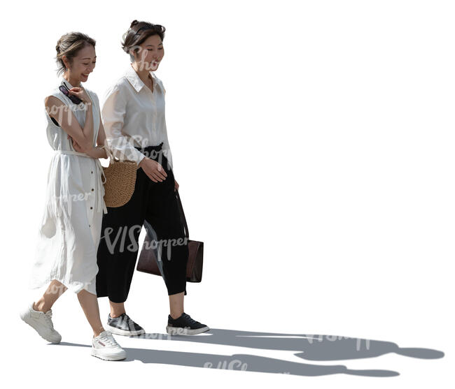 two backlit asian women walking