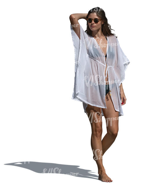 woman in a bikini and wearing a light beach kaftan walking