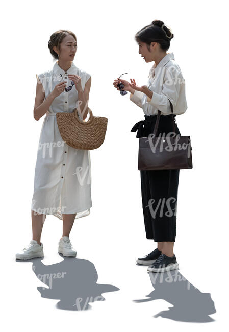 two backlit asian women standing and talking