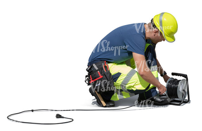 workman squatting and preparing an extension cord