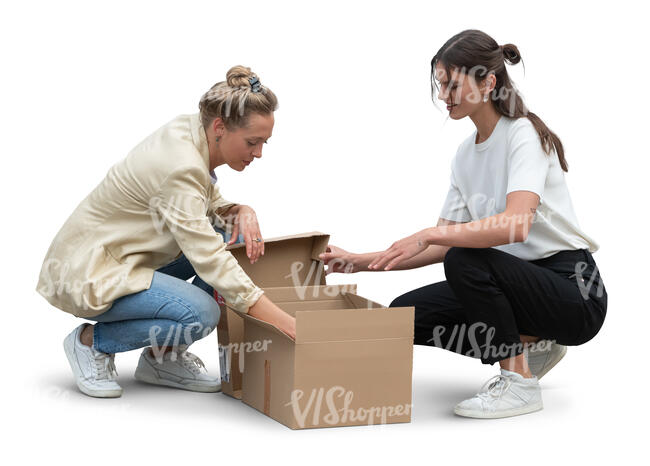 two women squatting and opening a carton box