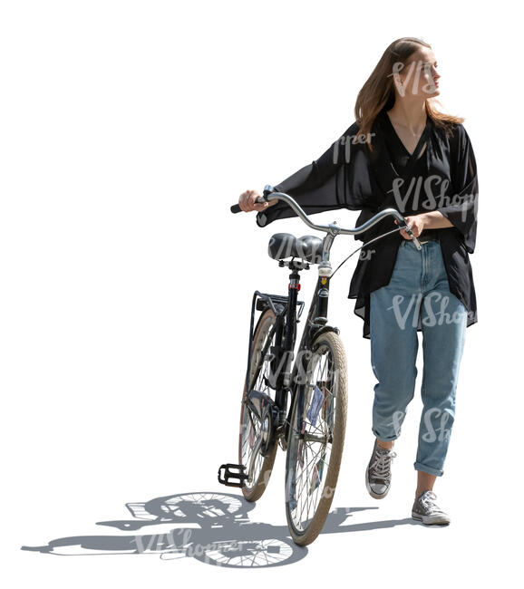 backlit young woman with a bike walking