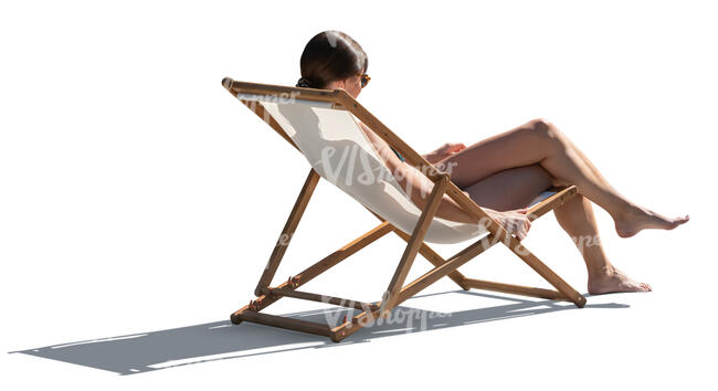 backlit woman sunbathing in beach chair