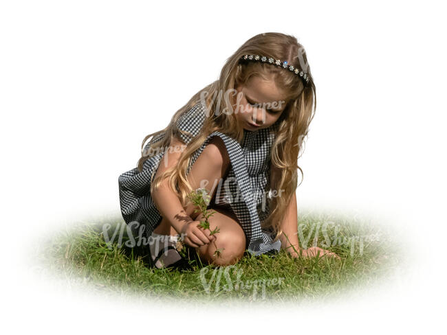 little girl sitting on the grass and picking flowers