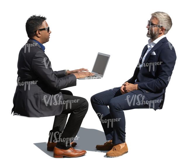 two businessmen sitting outside and talking