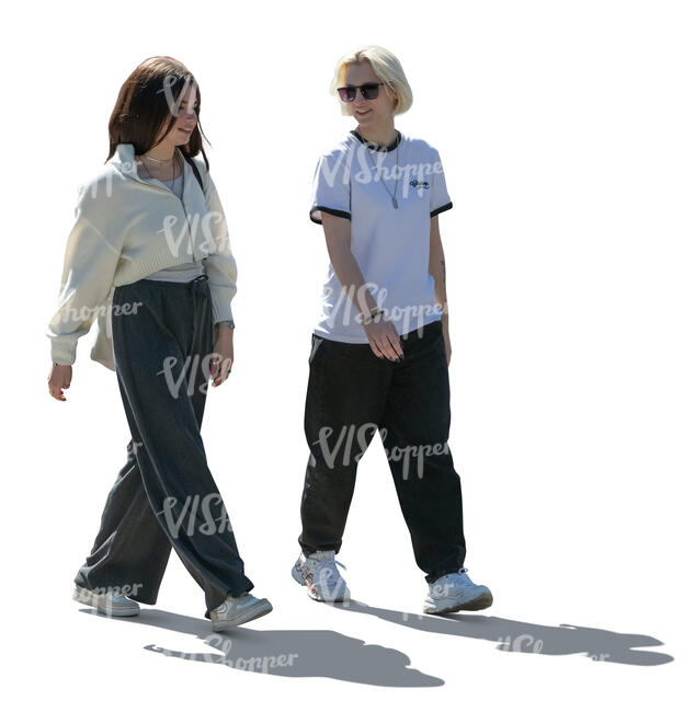 two backlit young women walking