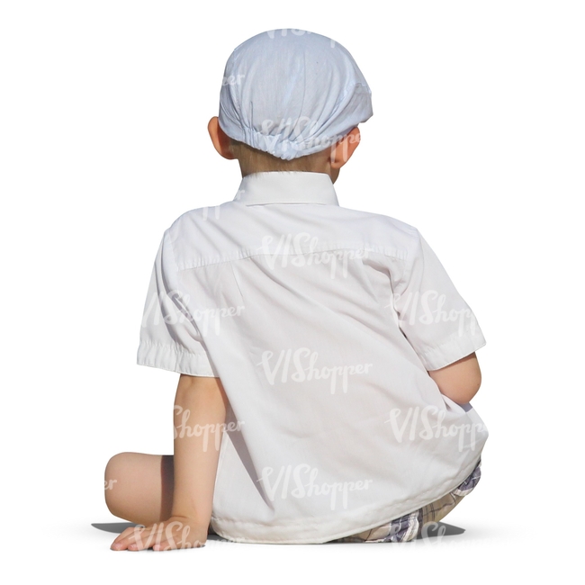 young boy in white sitting on the ground