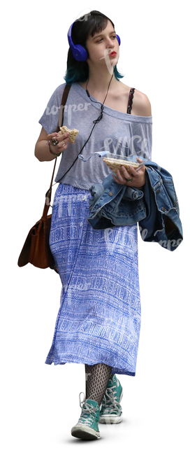 young woman with headphones walking and eating a sandwich 