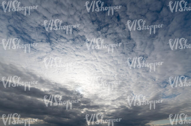 cloudy sky with sun behind grey clouds