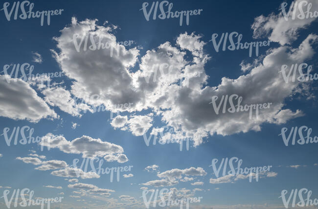 blue sky with backlit white clouds